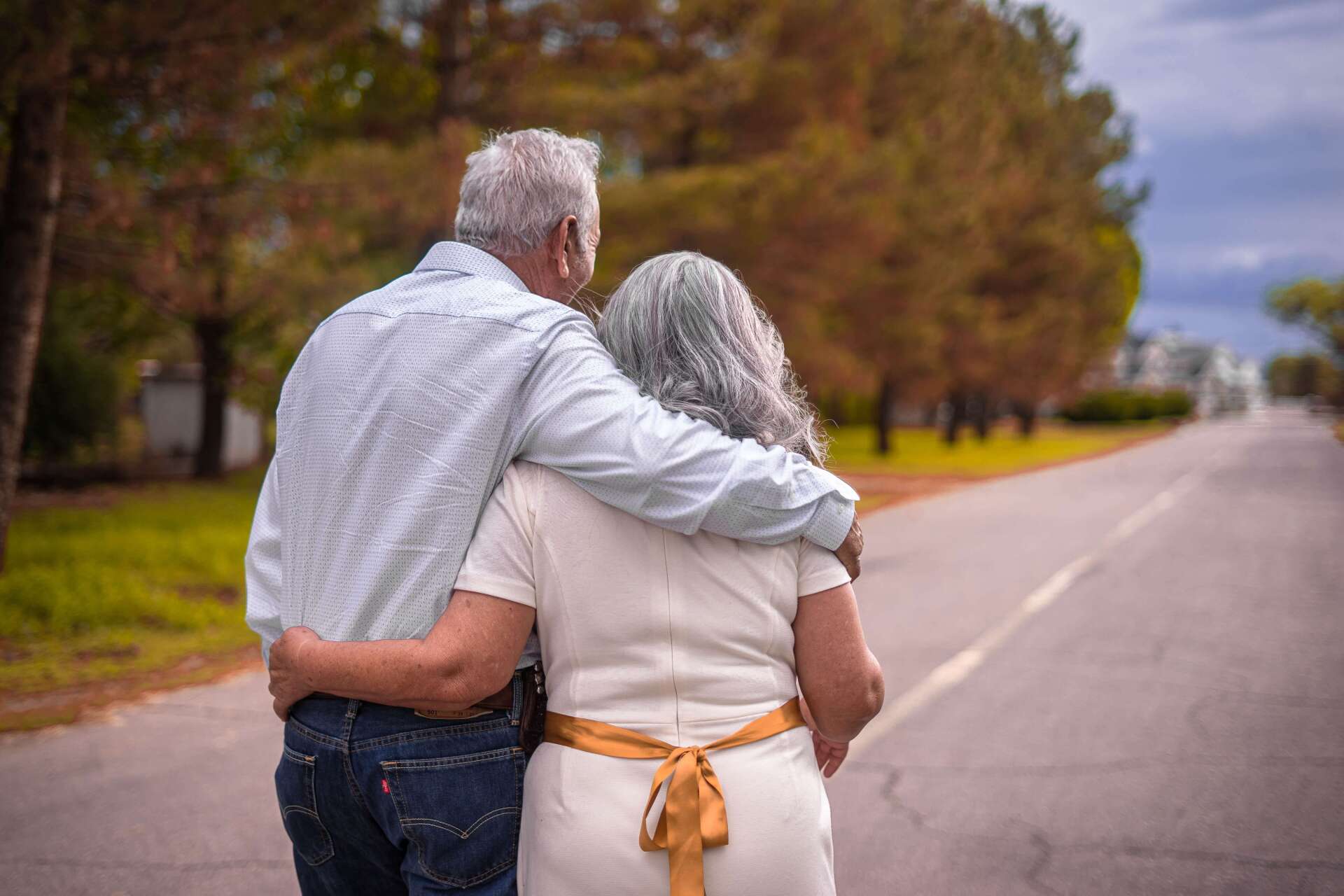 Elderly Couple Walking Down Road Thinking About Cremation Costs
