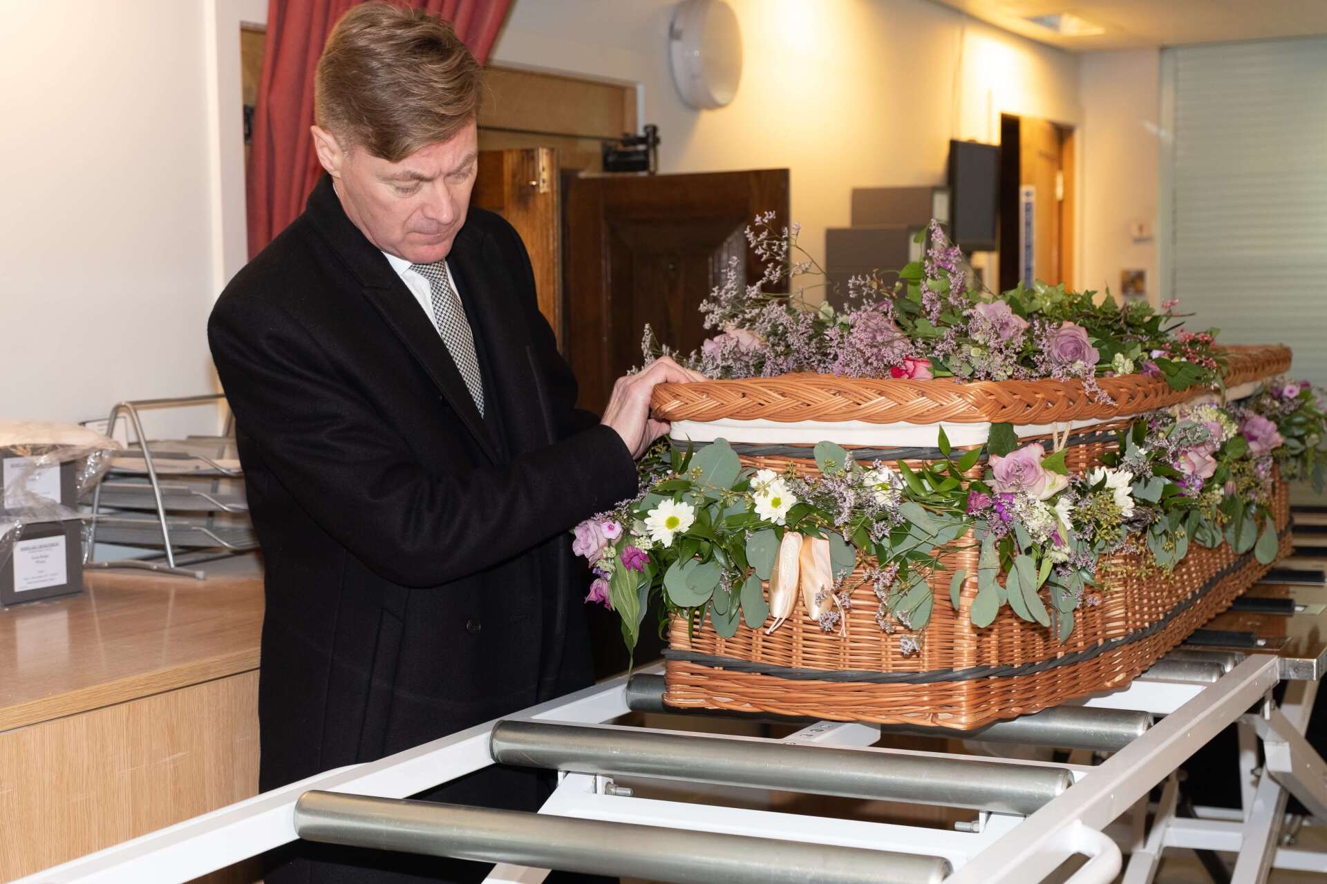 Man Hoisting Cremation Casket at Crematorium