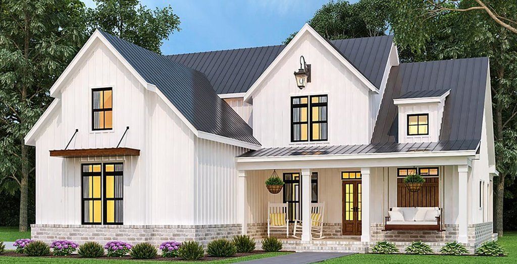 A white house with a black roof and a porch.