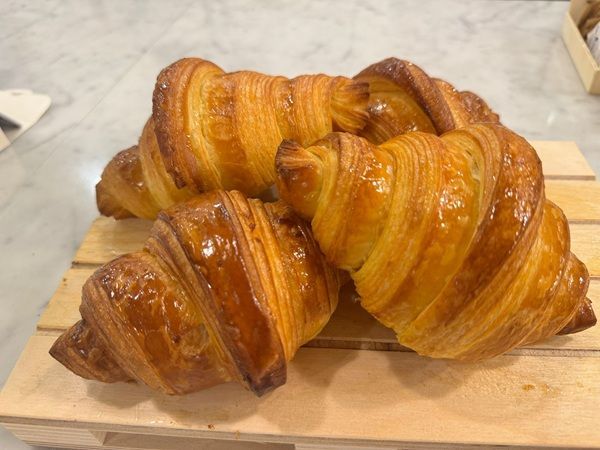 Tre croissant dorati su un tagliere di legno