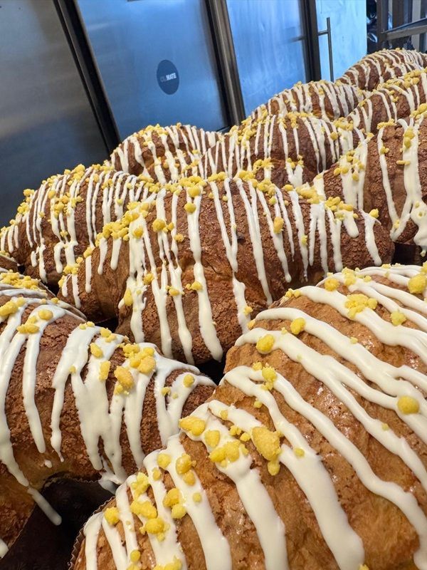 File di pasticcini dorati ricoperti di glassa bianca e guarniti con noci su un vassoio