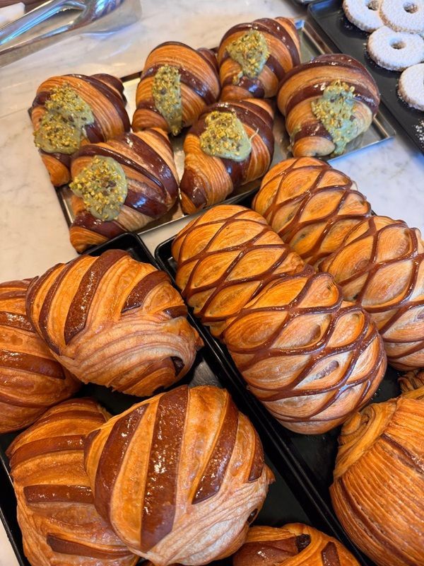 Assortimento di trecce di pane con crosta marrone lucida su un vassoio