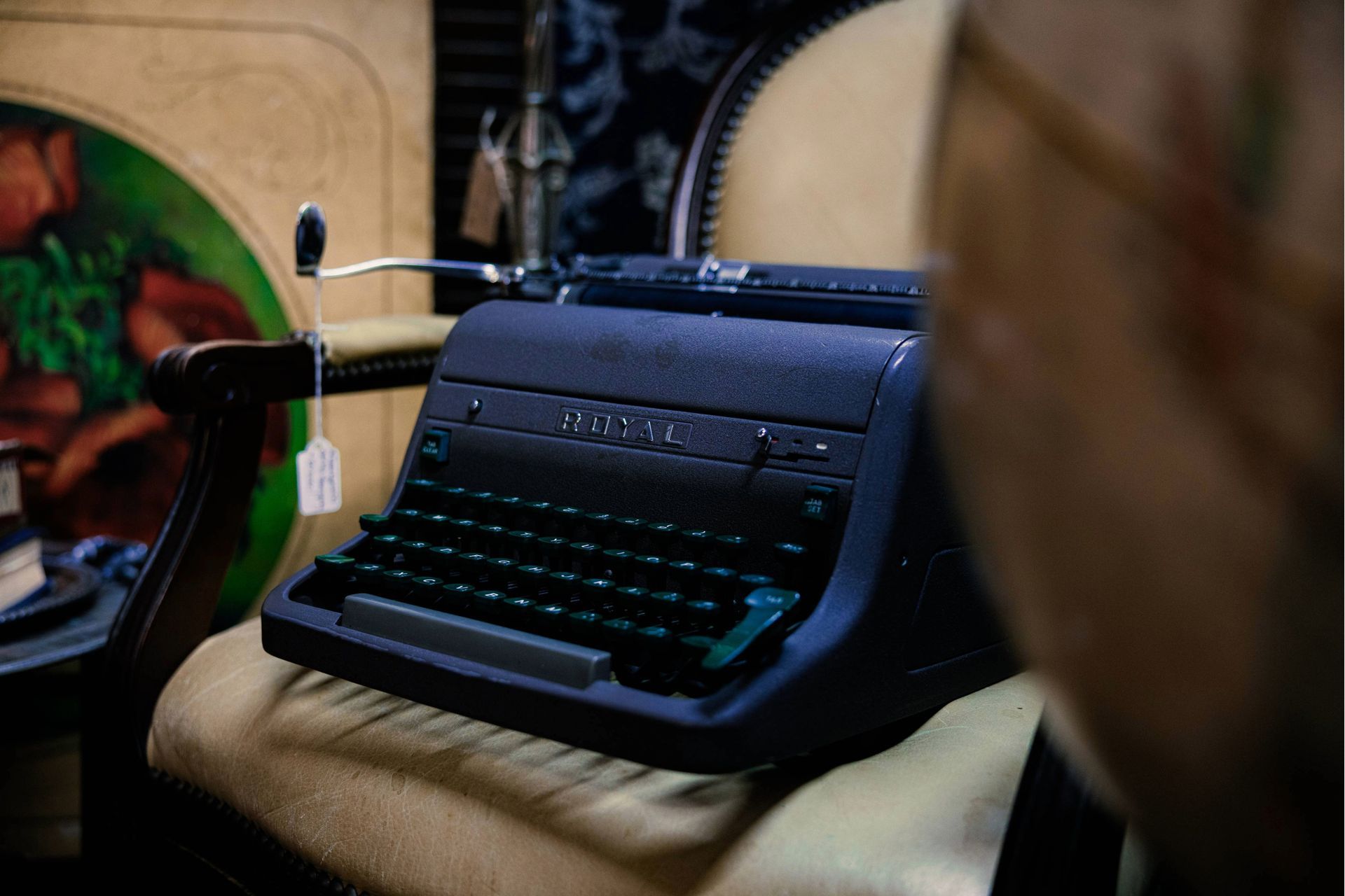 A black typewriter is sitting on top of a chair.