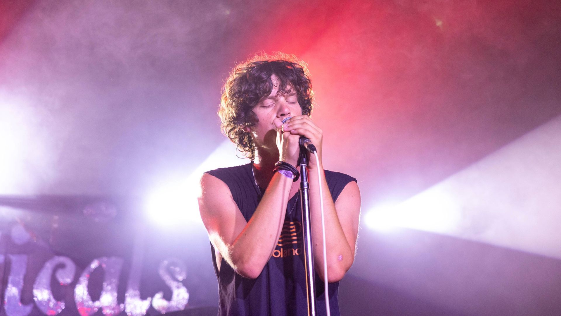 A man is singing into a microphone on a stage.