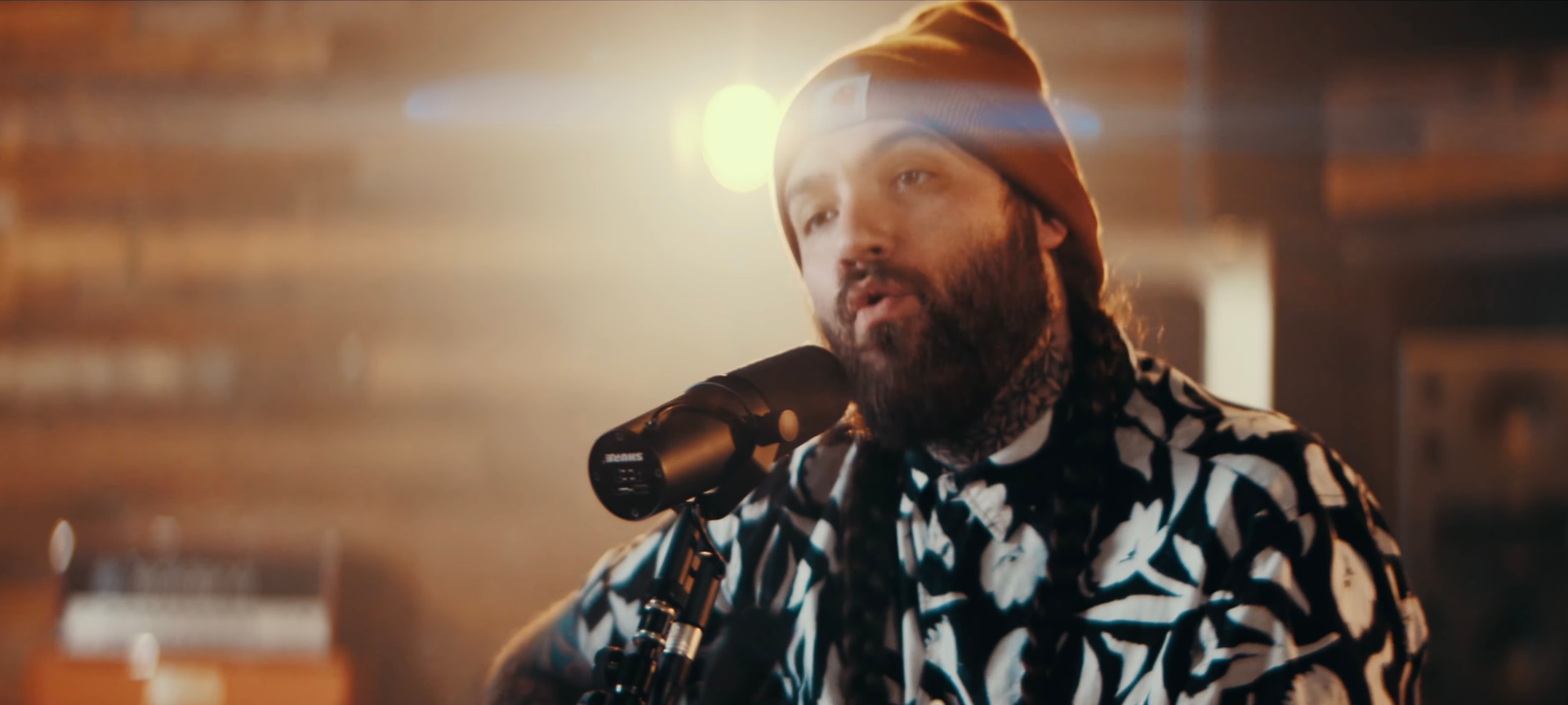 A man with a beard is singing into a microphone.