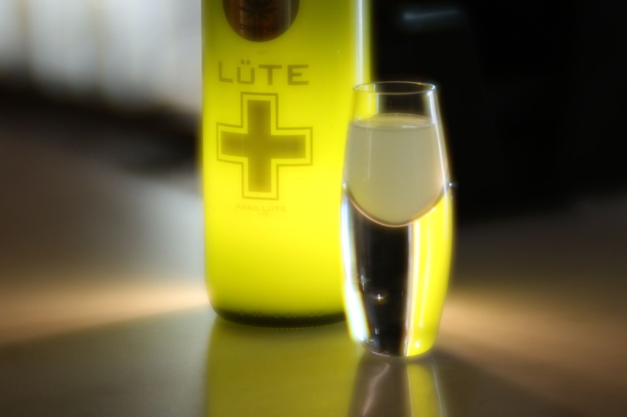 A bottle of lute next to a shot glass