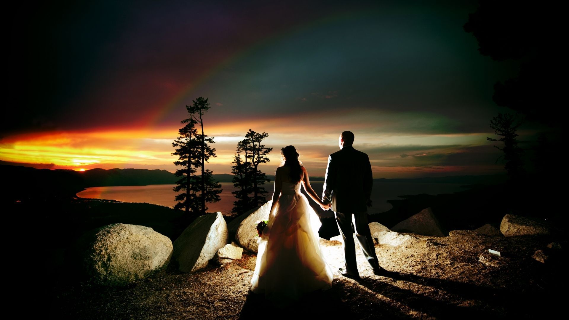 A Couple stares at a sunset in the desert.