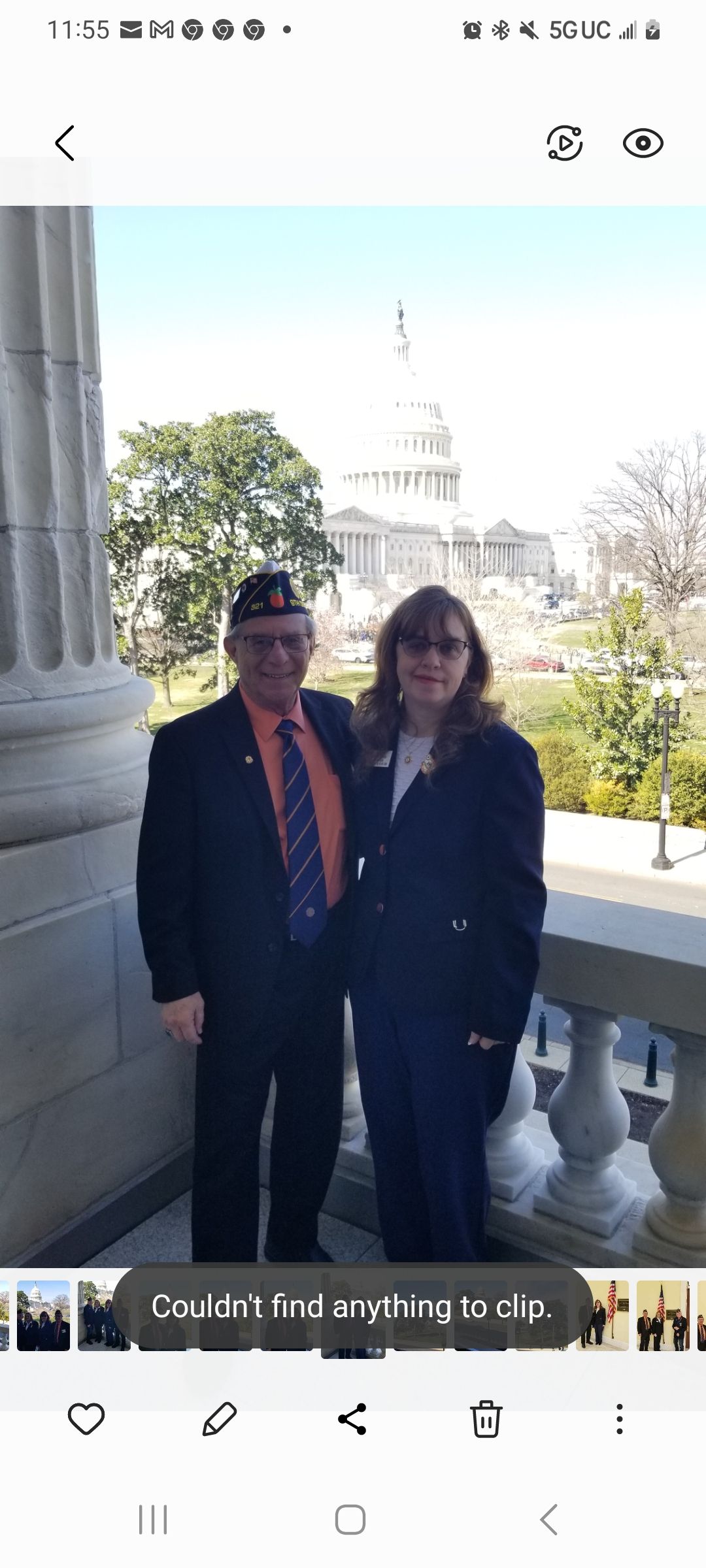 A man and a woman are posing for a picture in front of a building.