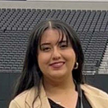 A man in a blue suit smiling at the camera