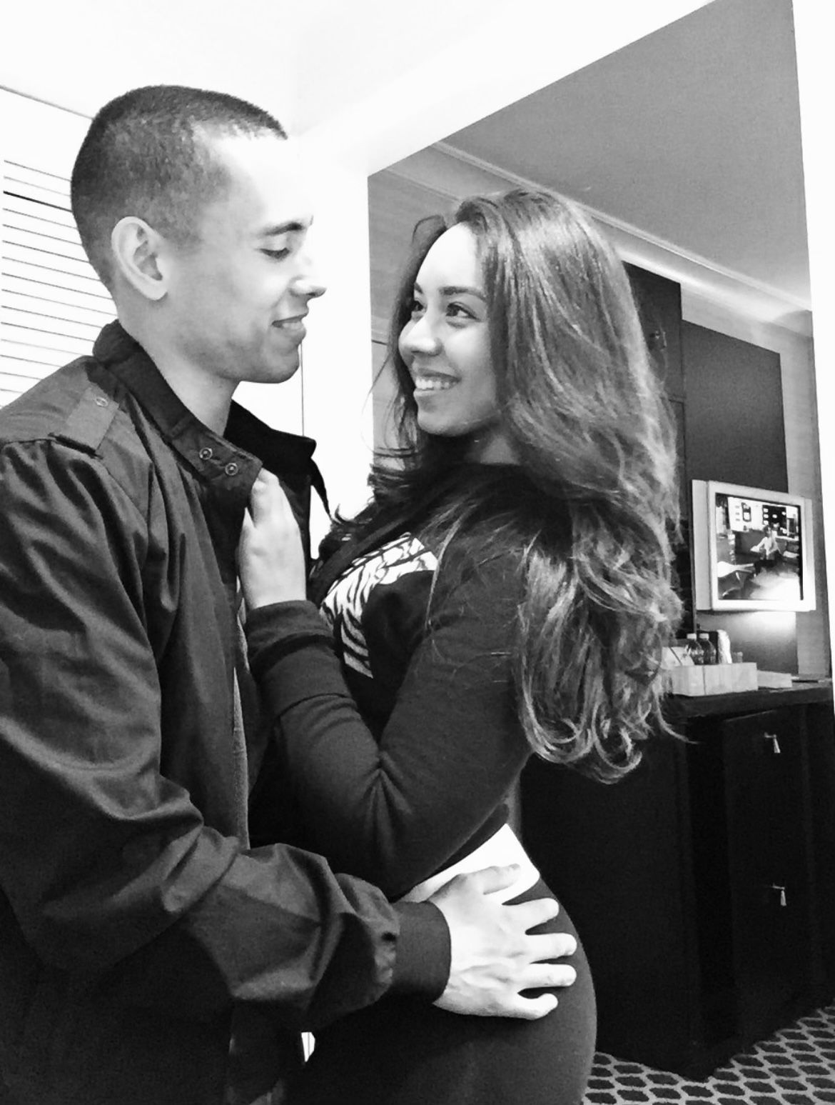 A black and white photo of a man and woman hugging