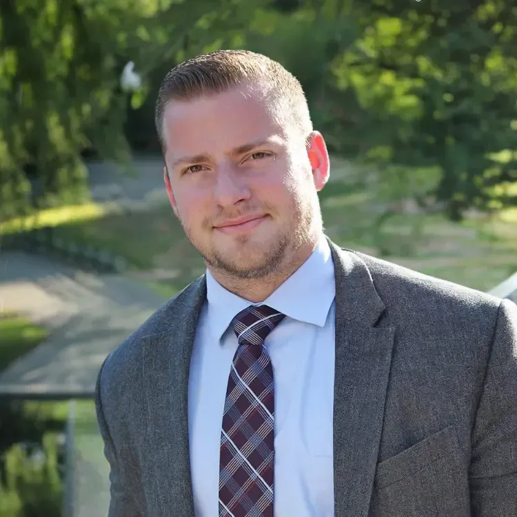 A man in a suit and tie is smiling for the camera.