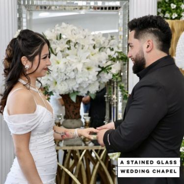 A woman in a stained glass wedding chapel is smiling.