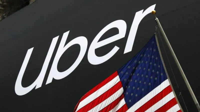 Uber logo next to the American flag. The Uber logo is white on black.
