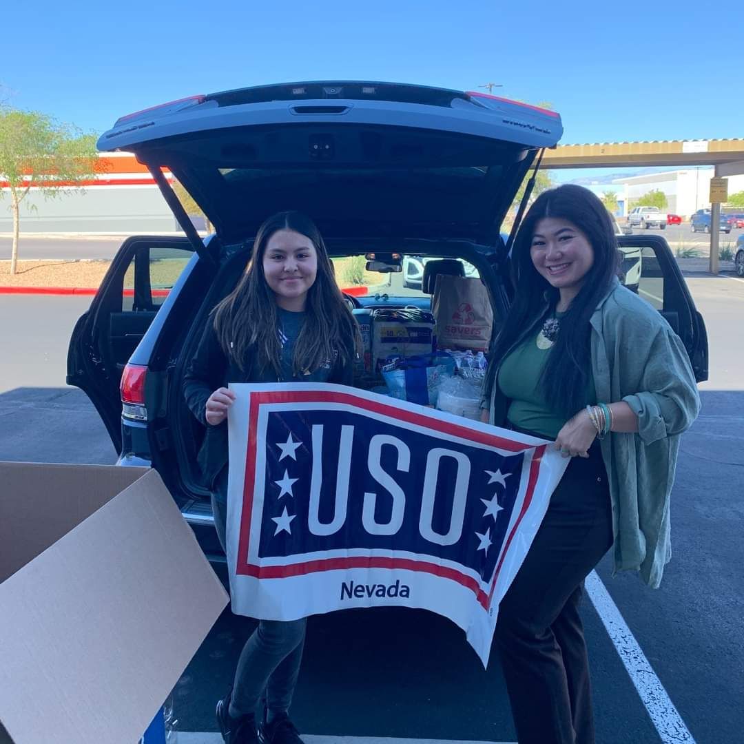 Vegas Wedding Chamber Community Outreach Chair poses w/ USO Flag before presenting donations to USO.