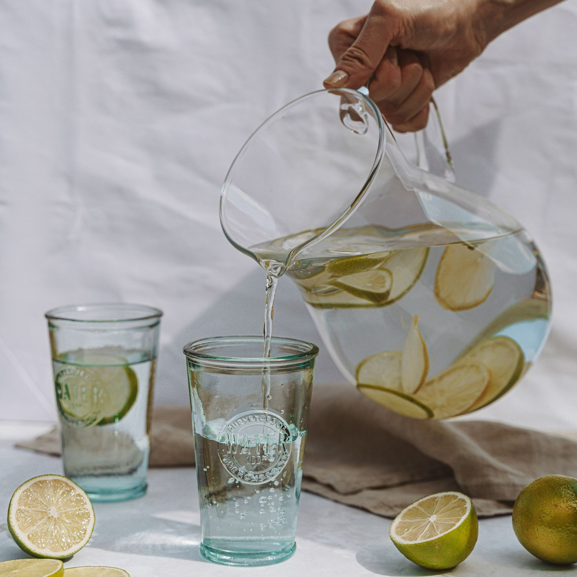 A pitcher of water is being poured into a glass
