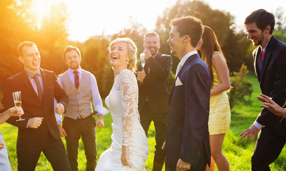 Bride & Groom smiling while surrounded by wedding guests