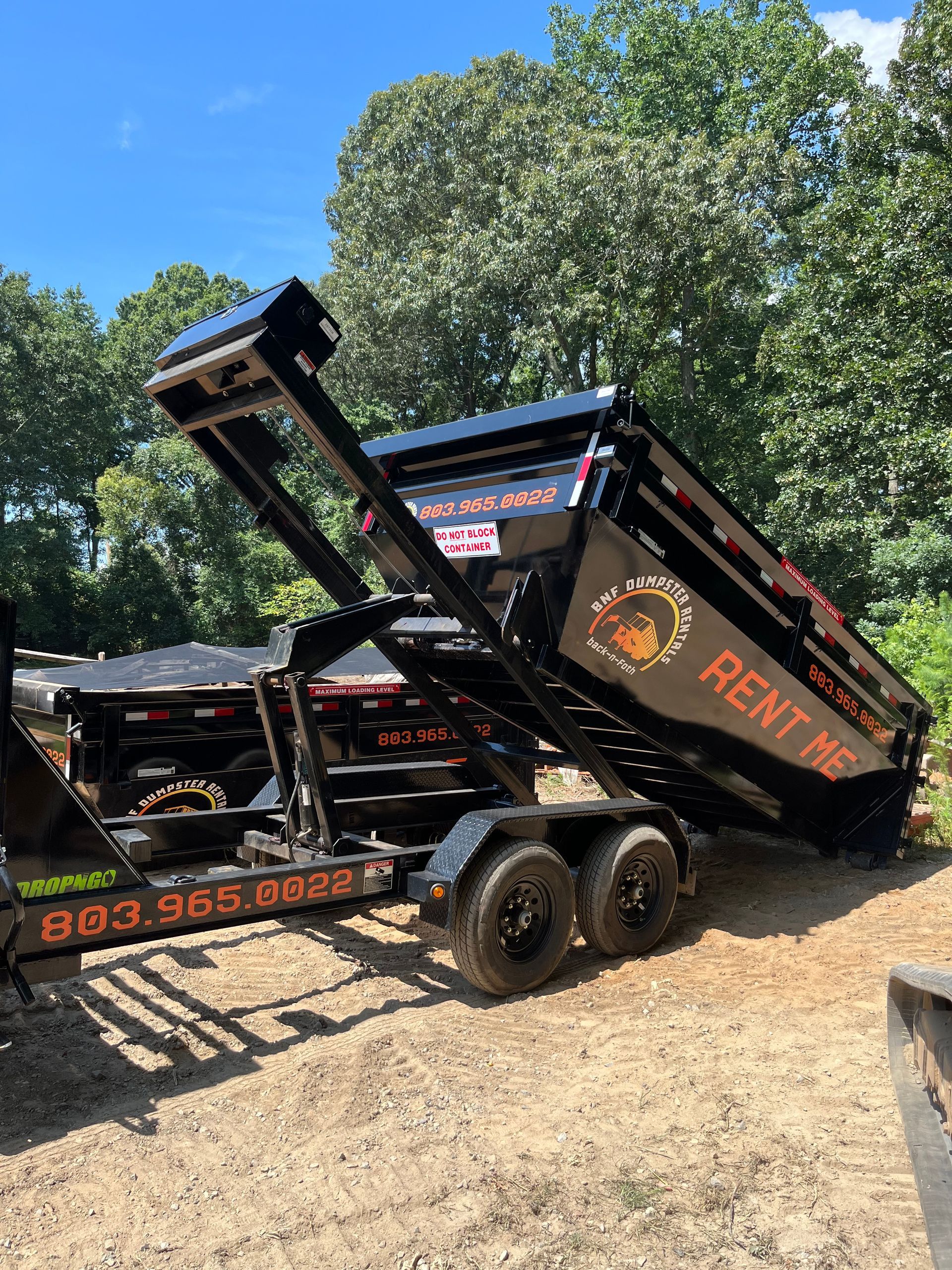 A black dumpster in a open area