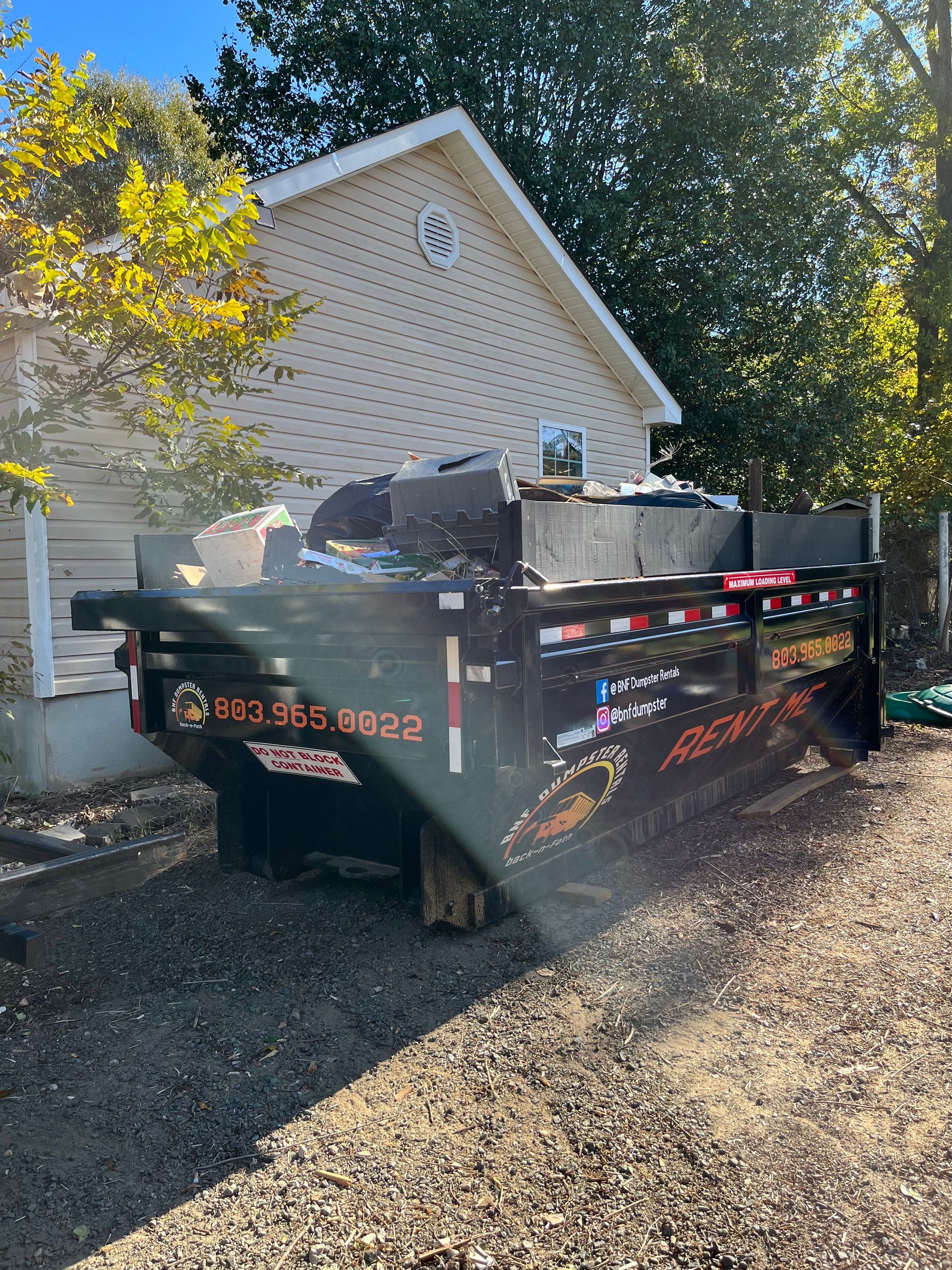 a dumpster is parked in front of a house .
