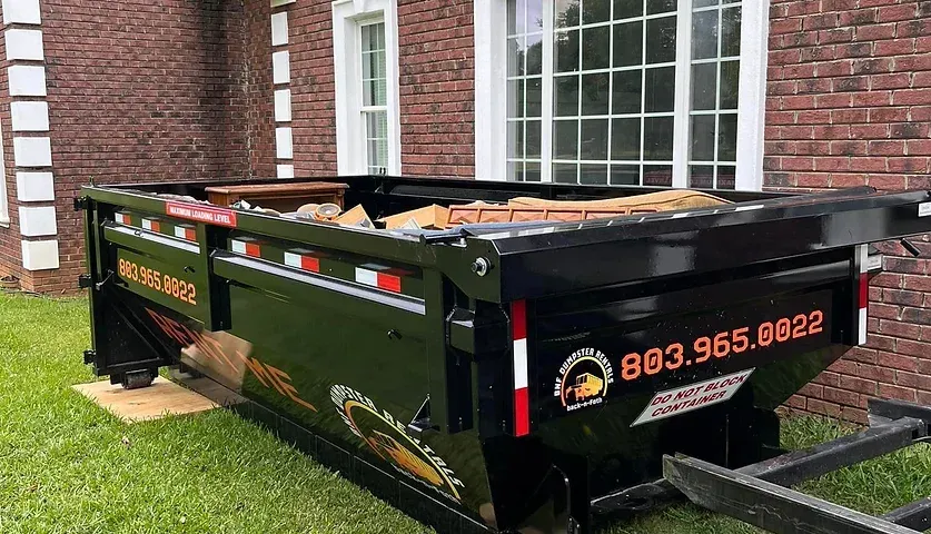 a dumpster is parked in front of a brick house .