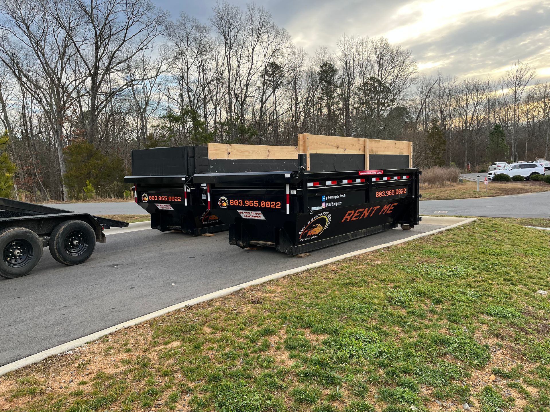 Two dumpsters in a parking