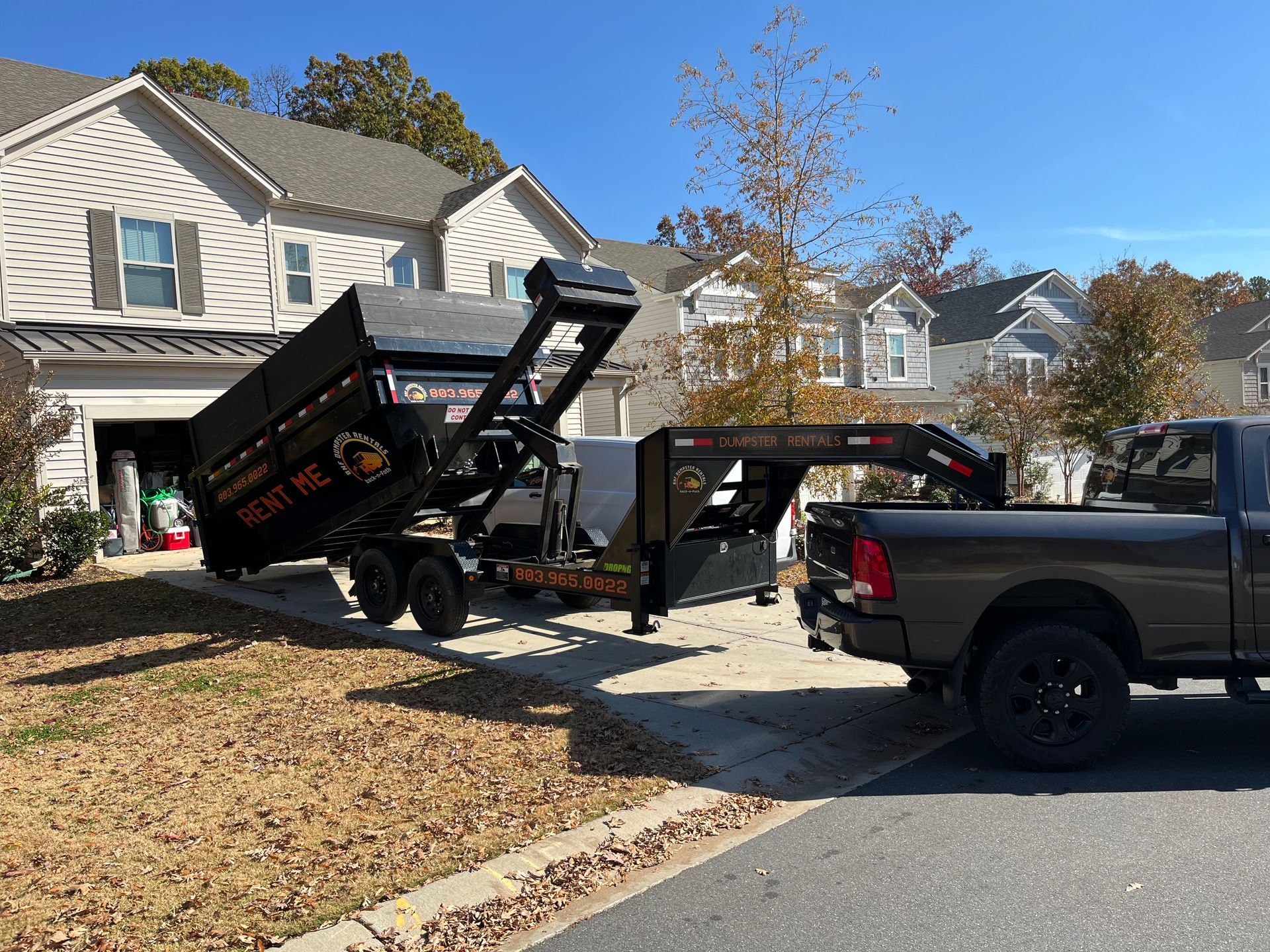 A large metal dumpster in a residential driveway