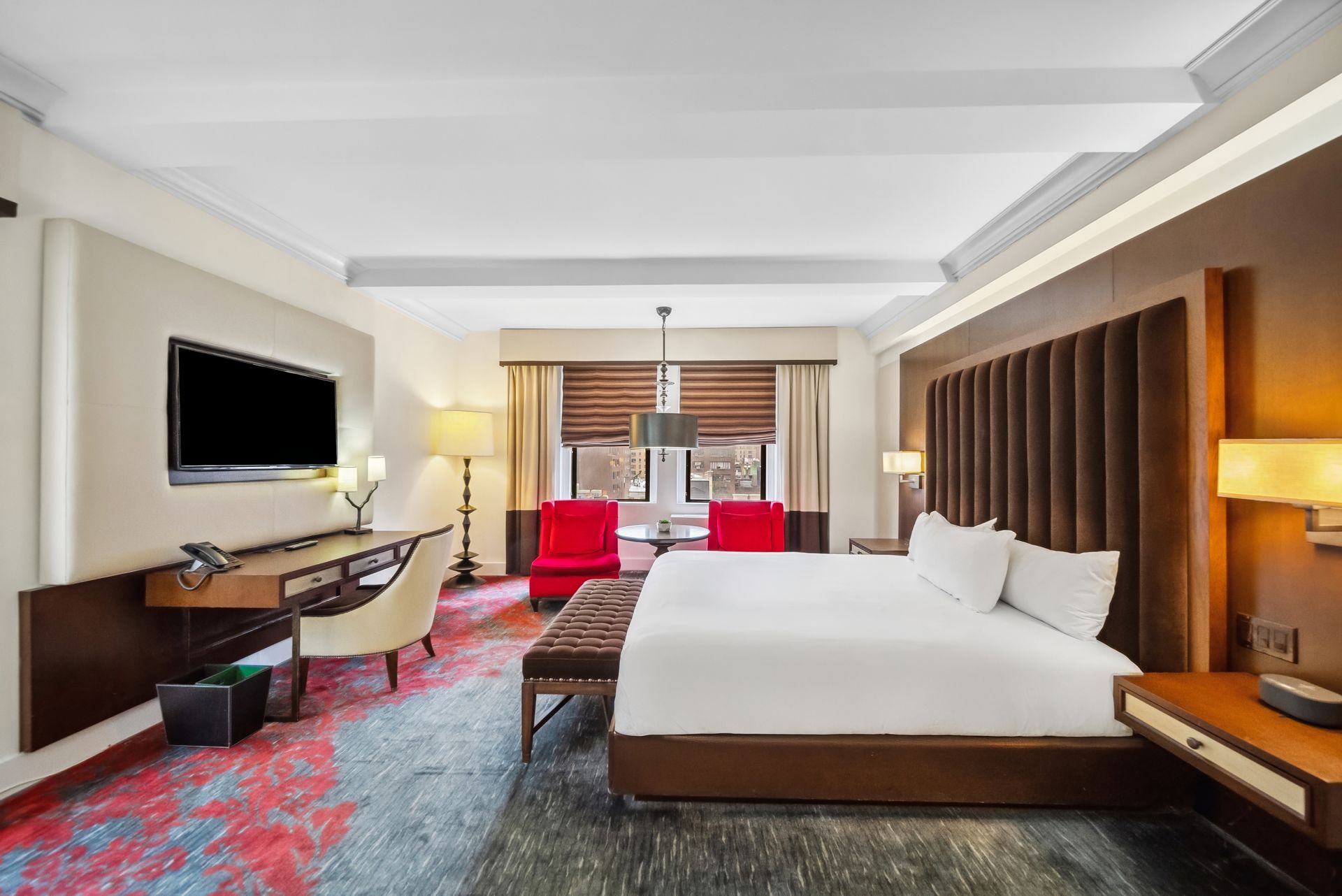 A hotel room with a king size bed and a flat screen tv.