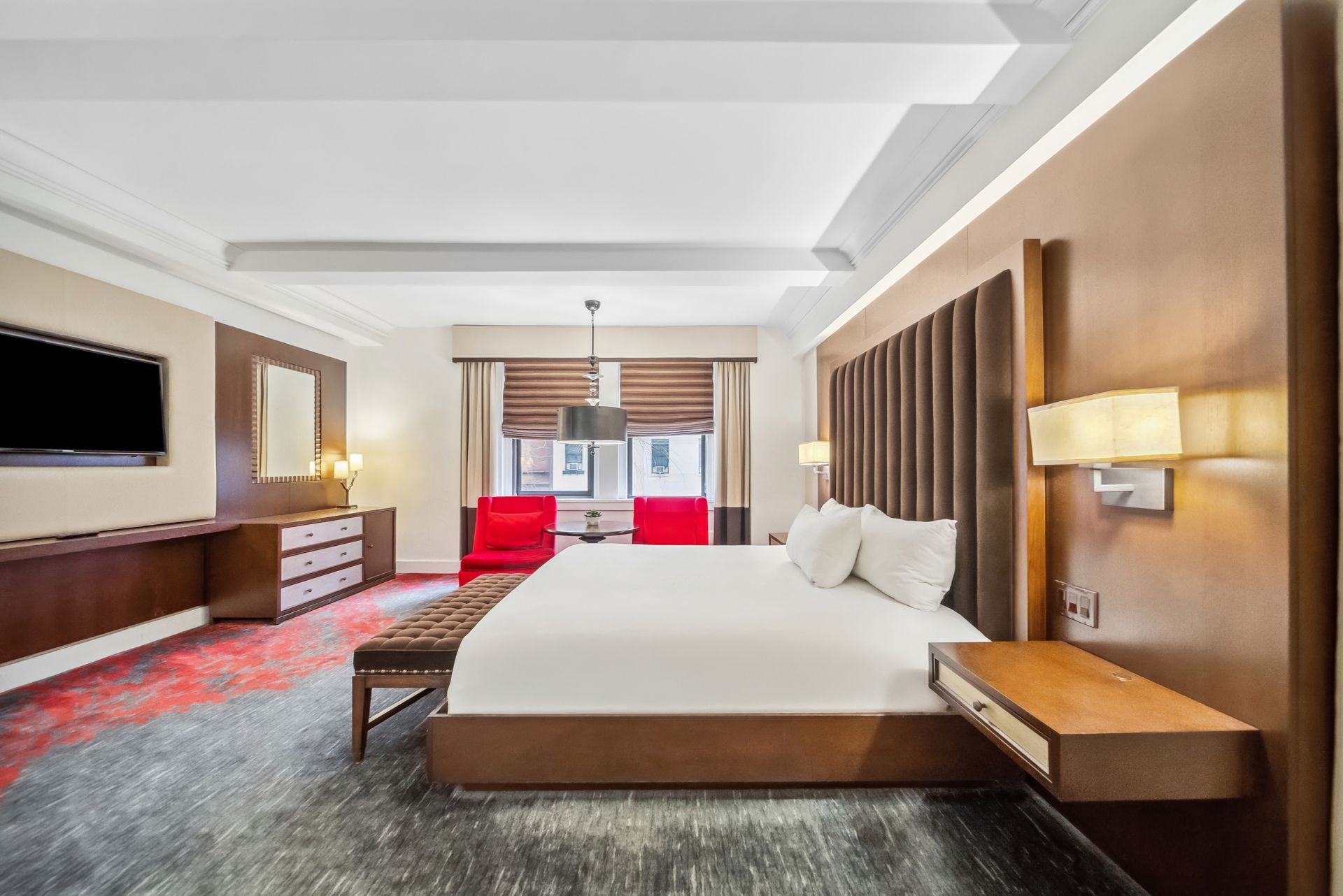 A hotel room with a king size bed and a flat screen tv.