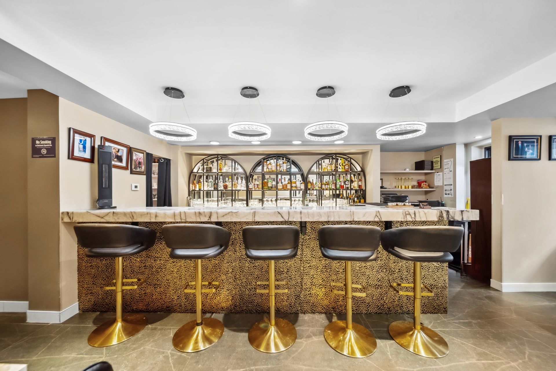 A bar with a long counter and stools in a room.