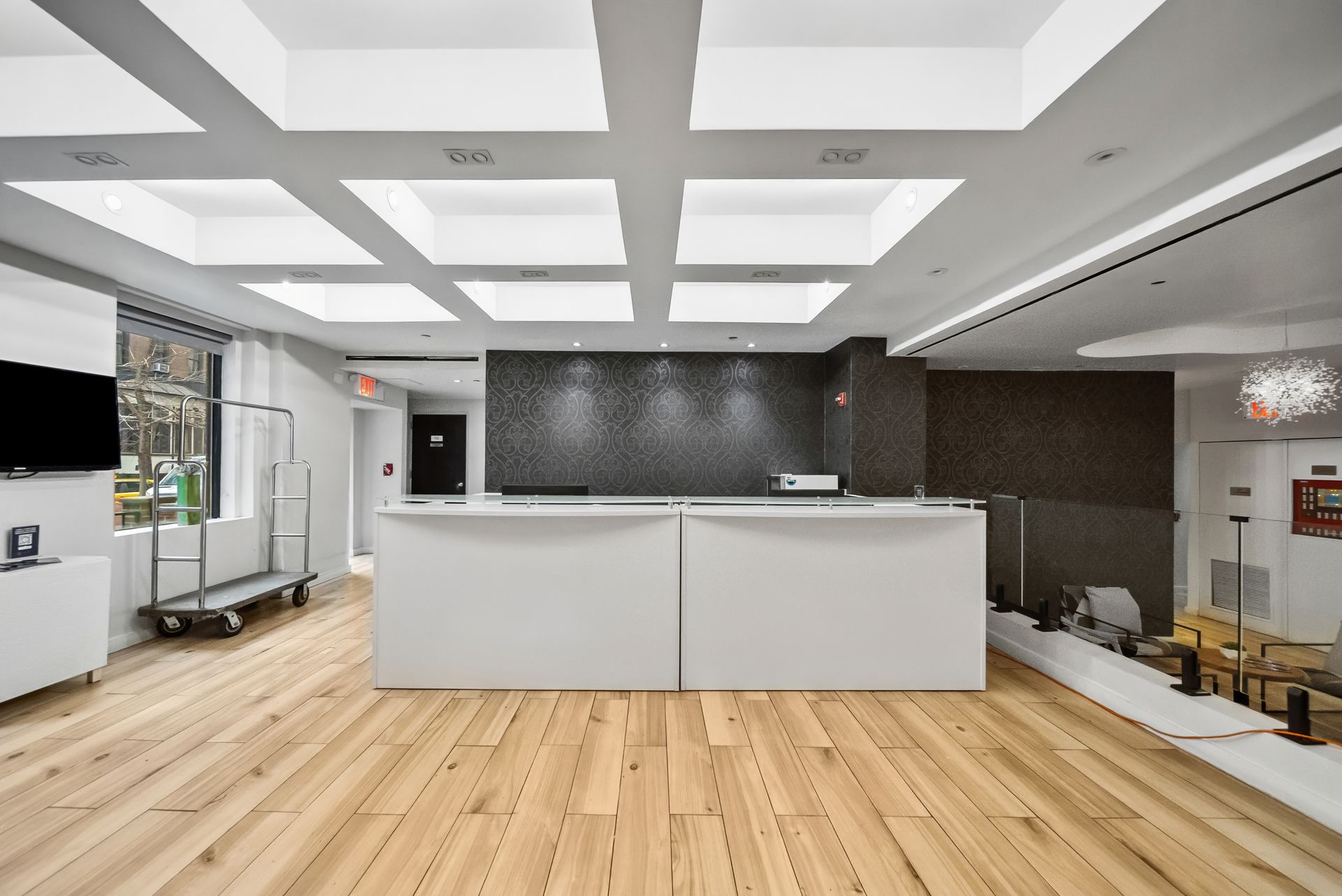 A large room with a wooden floor and a white counter.
