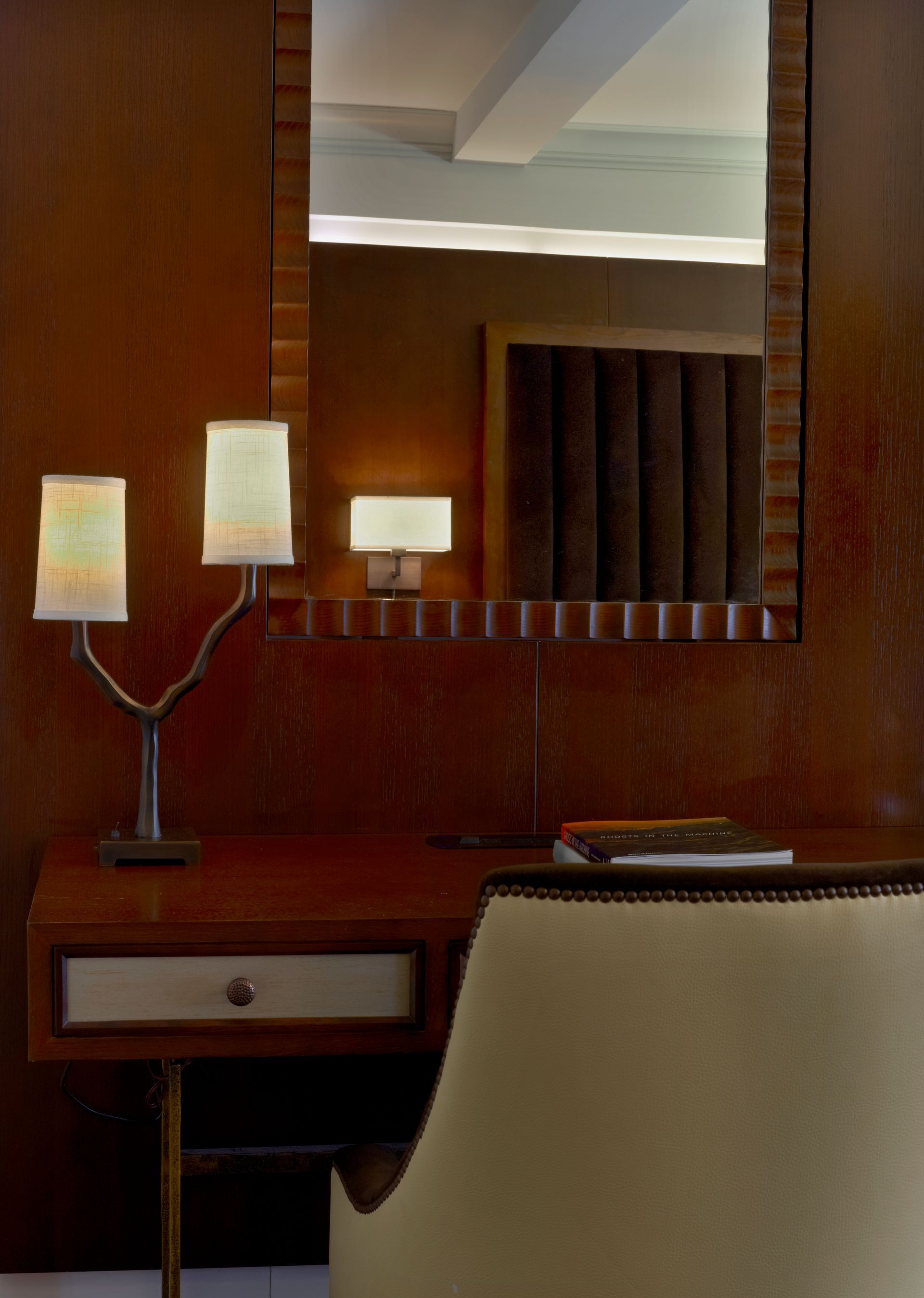 A room with a desk and chair and a mirror