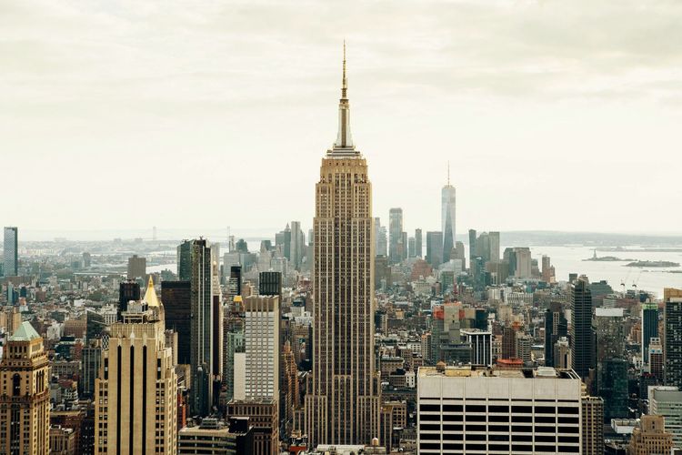 An aerial view of a city skyline with the empire state building in the foreground.