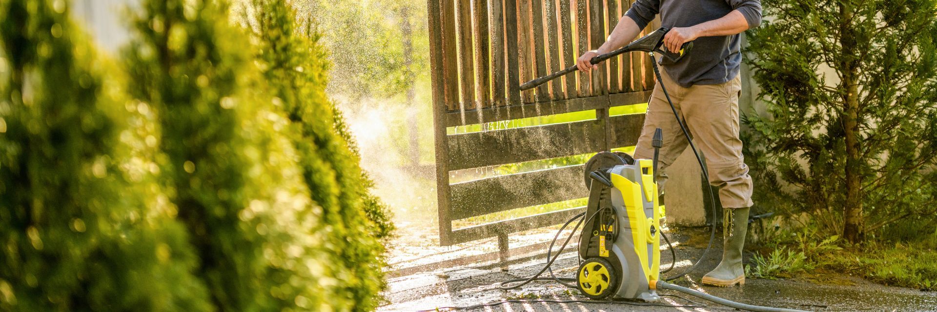 man cleaning the gate using pressure washer
