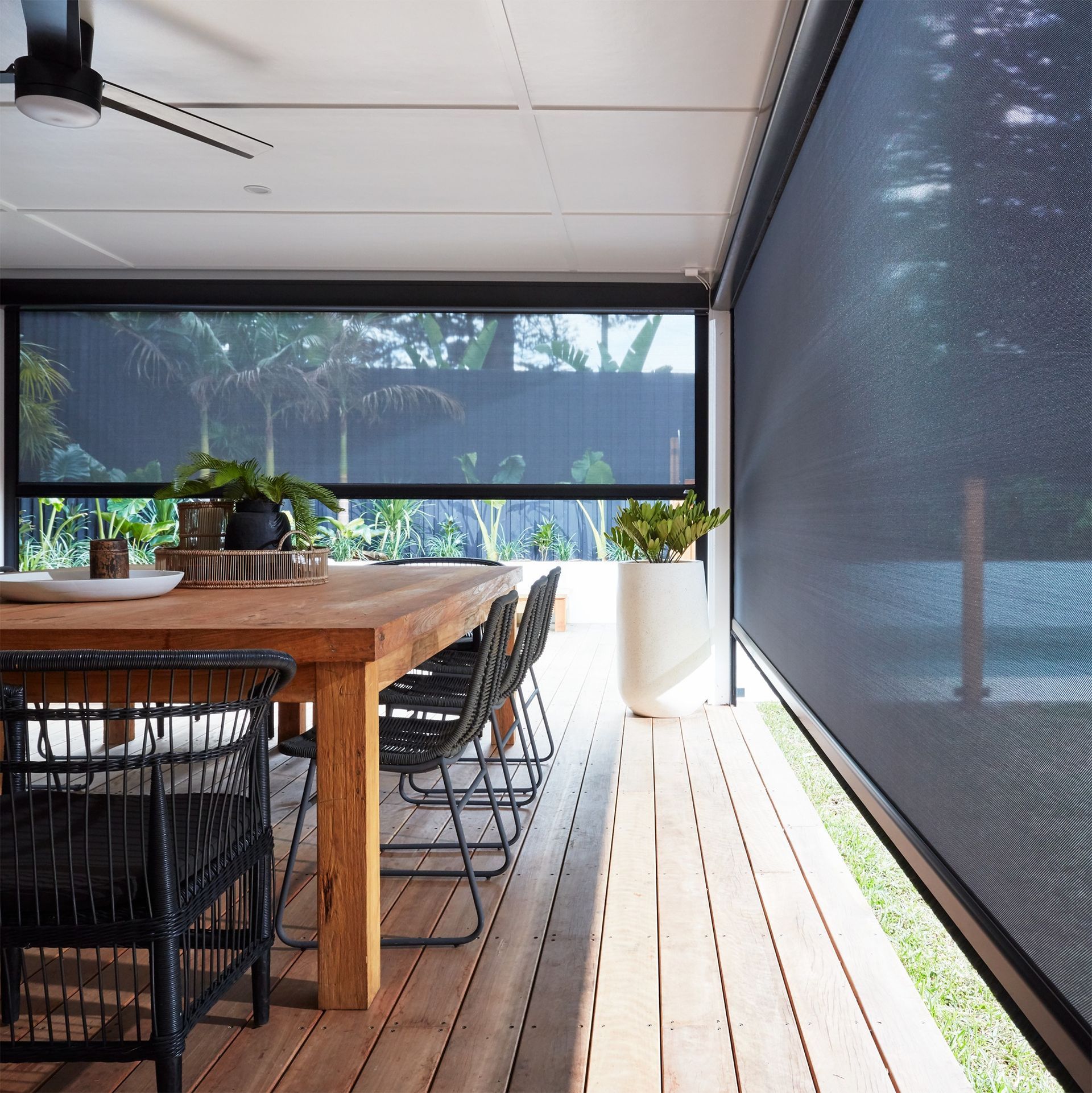 A dining room with a wooden table and chairs and a large window.