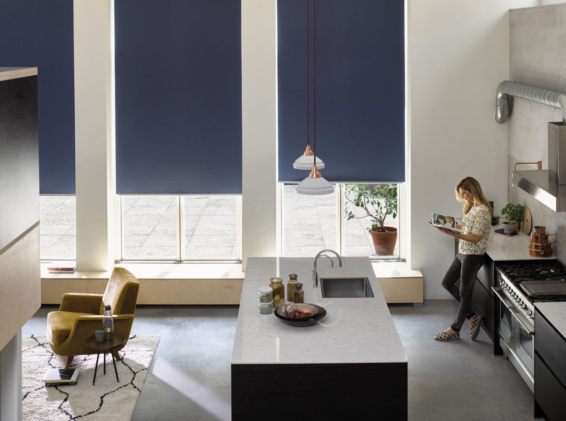 A living room with two white chairs and two windows with blinds.