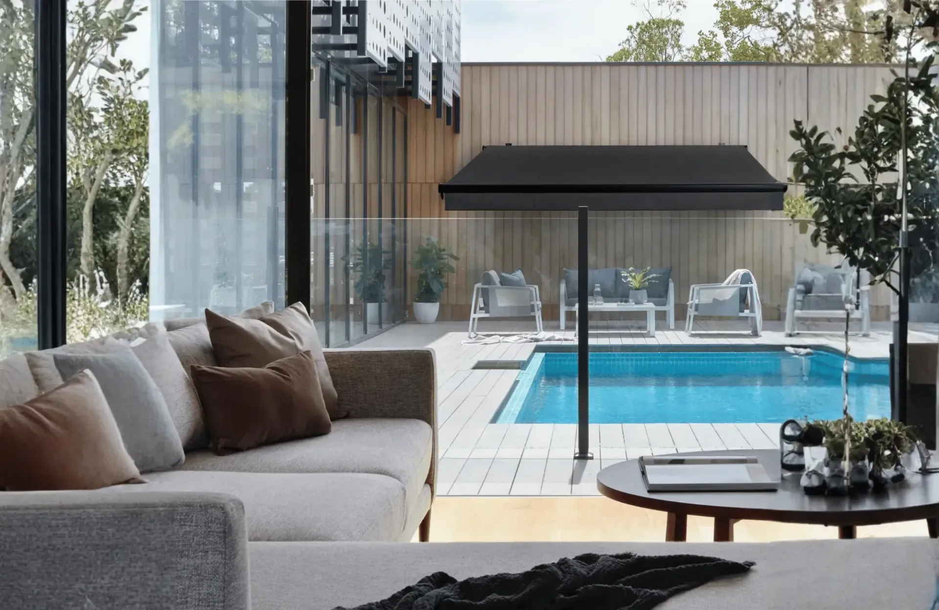 A balcony with a chair and a bed overlooking a lake.