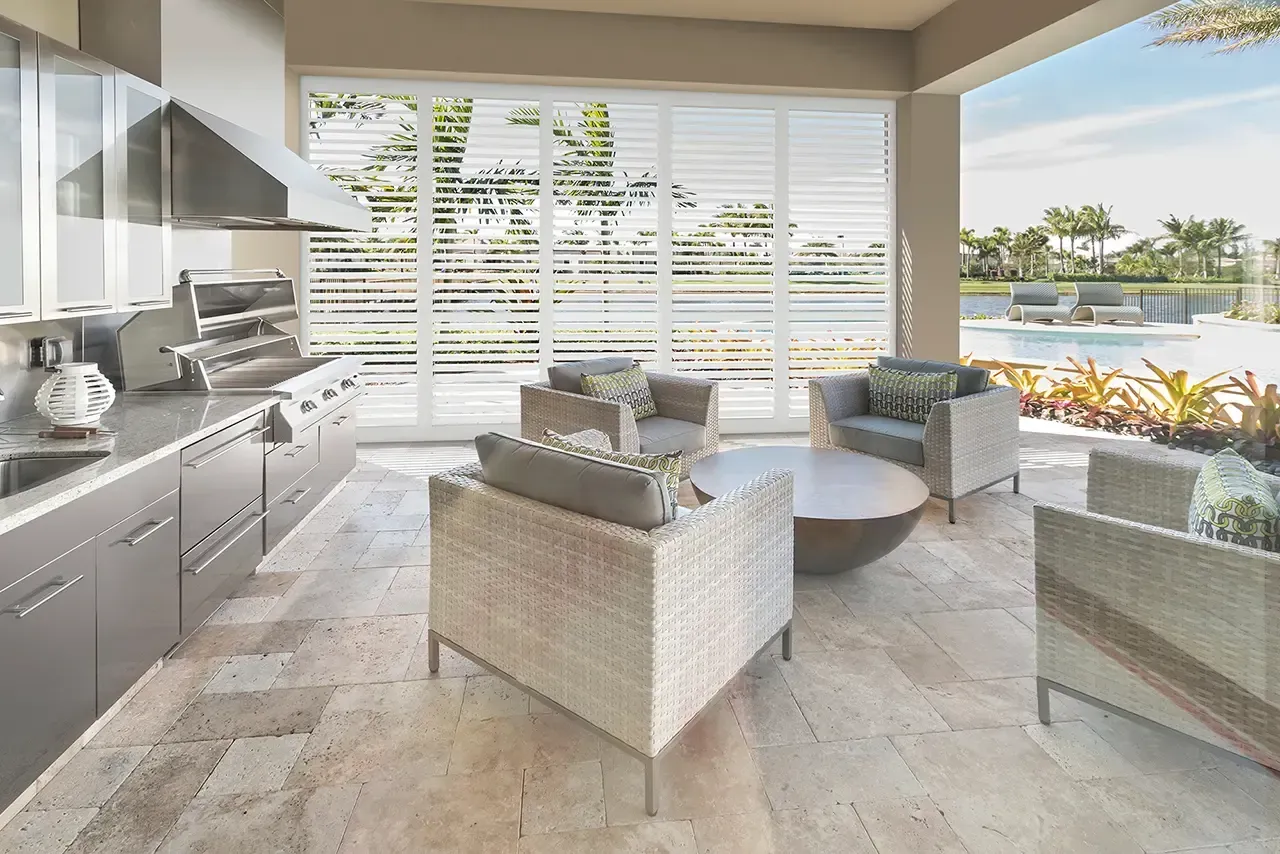 A bathroom with blue walls and white shutters on the windows.