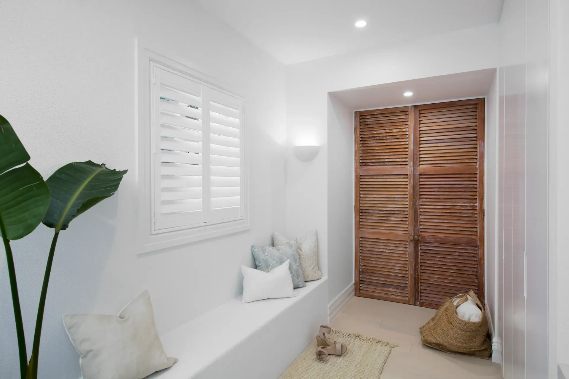 A bathroom with blue walls and white shutters on the windows.
