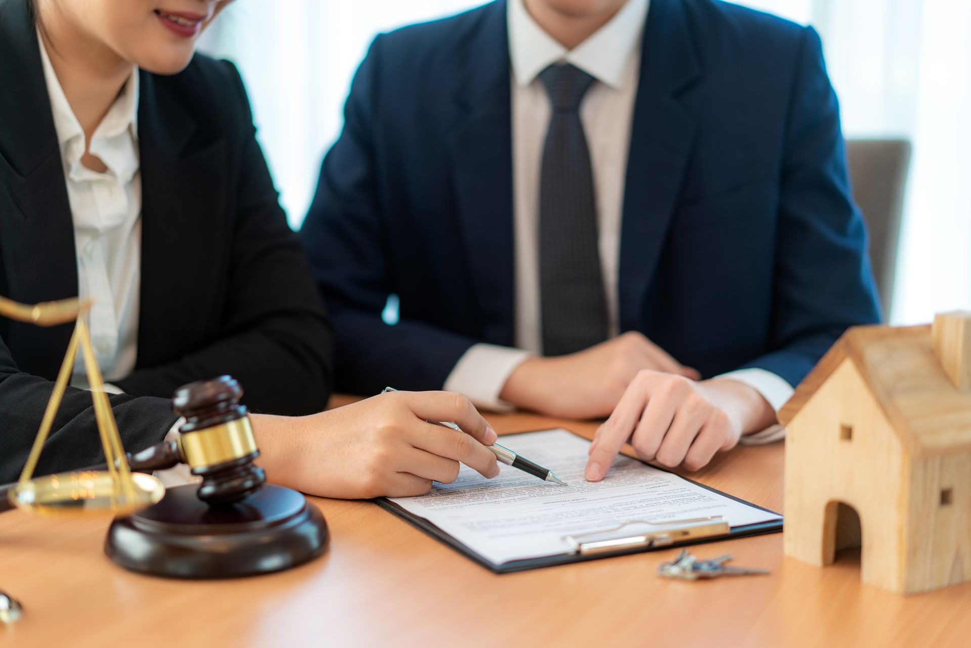 A man and a woman are sitting at a table looking at a piece of paper.
