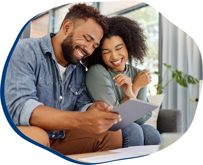 Young happy mixed race couple going through documents and using a digital tablet