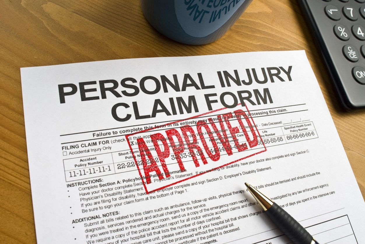 A Personal Injury Claim Form on a desk, stamped 