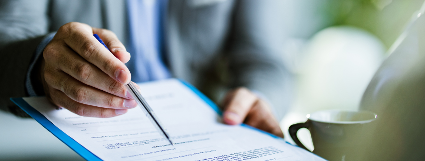 Personal injury claims text on papers with a pencil, clock, and striped folder on a desk
