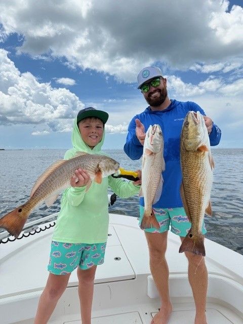 Father and son holding their catch