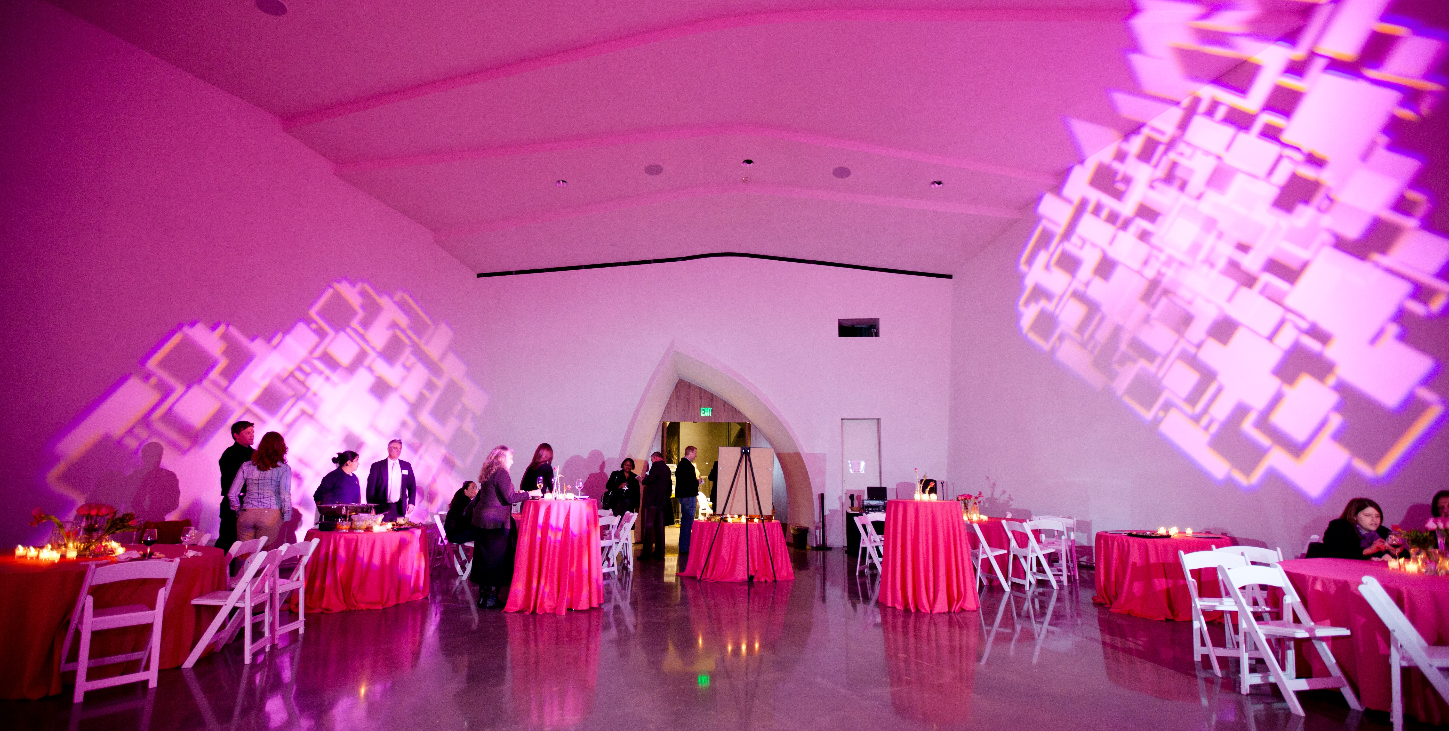 Wedding reception setting in Interfaith Peace Chapel.  Pink Tablecloths and lighting effects on the walls