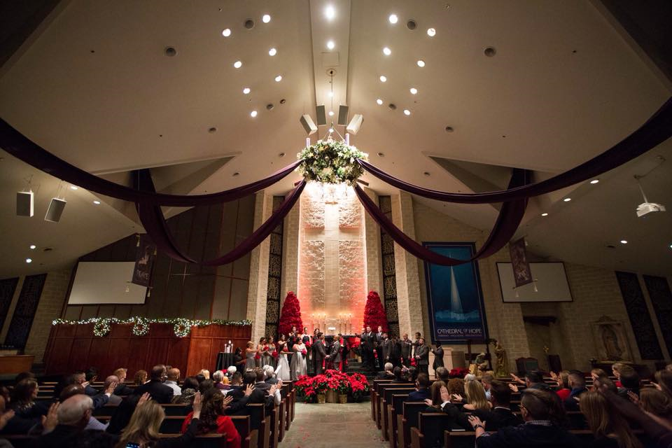 Wedding held during Advent with large poinsettia Christmas trees flanking the alter.
