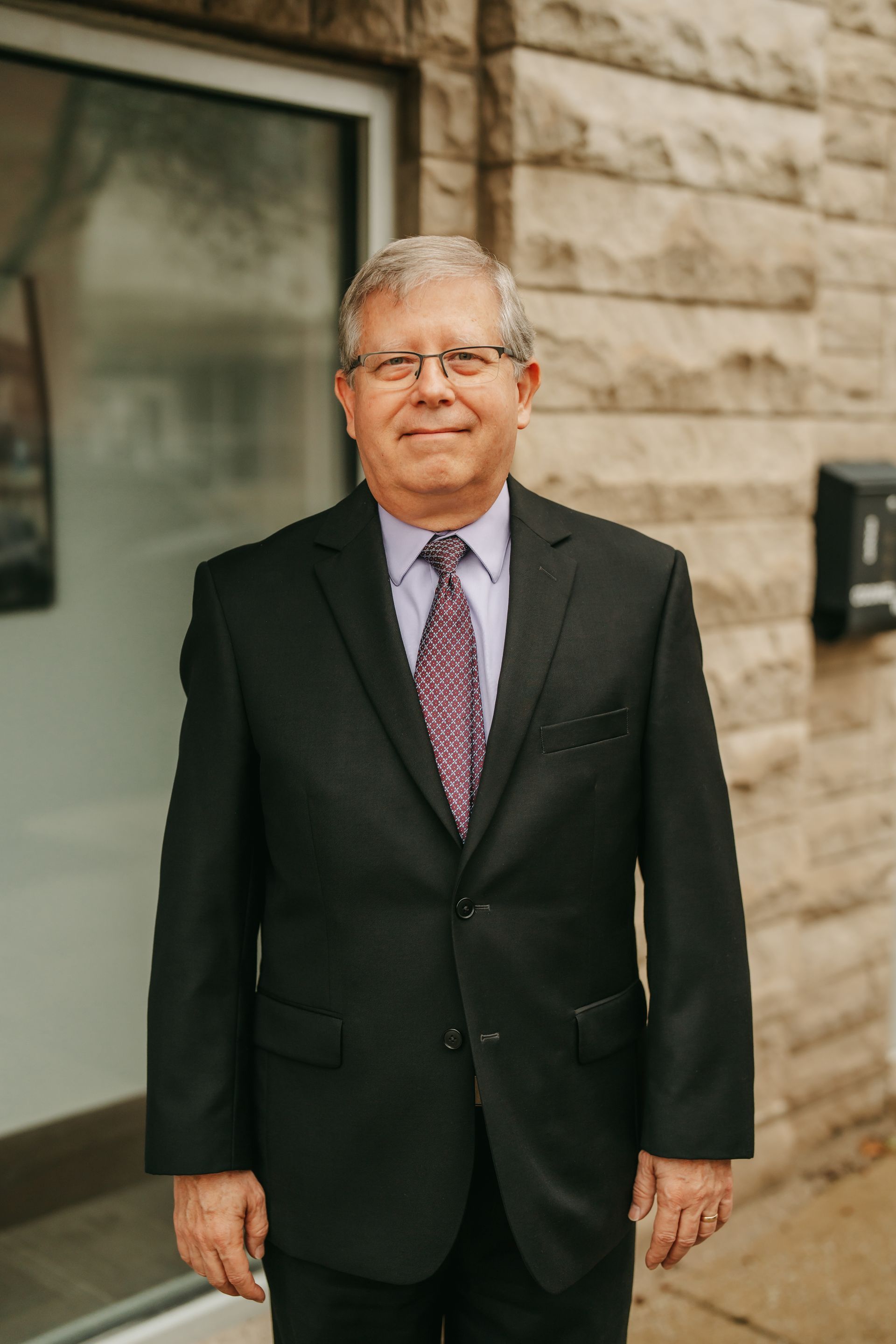 A man in a suit and tie is smiling for the camera.
