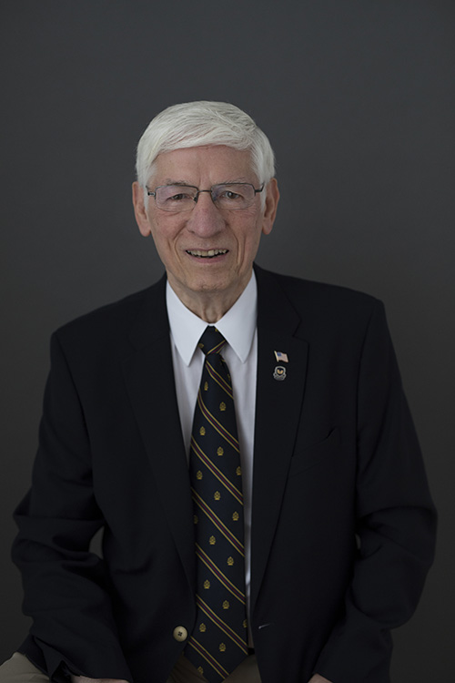 A man in a suit and tie is smiling for the camera