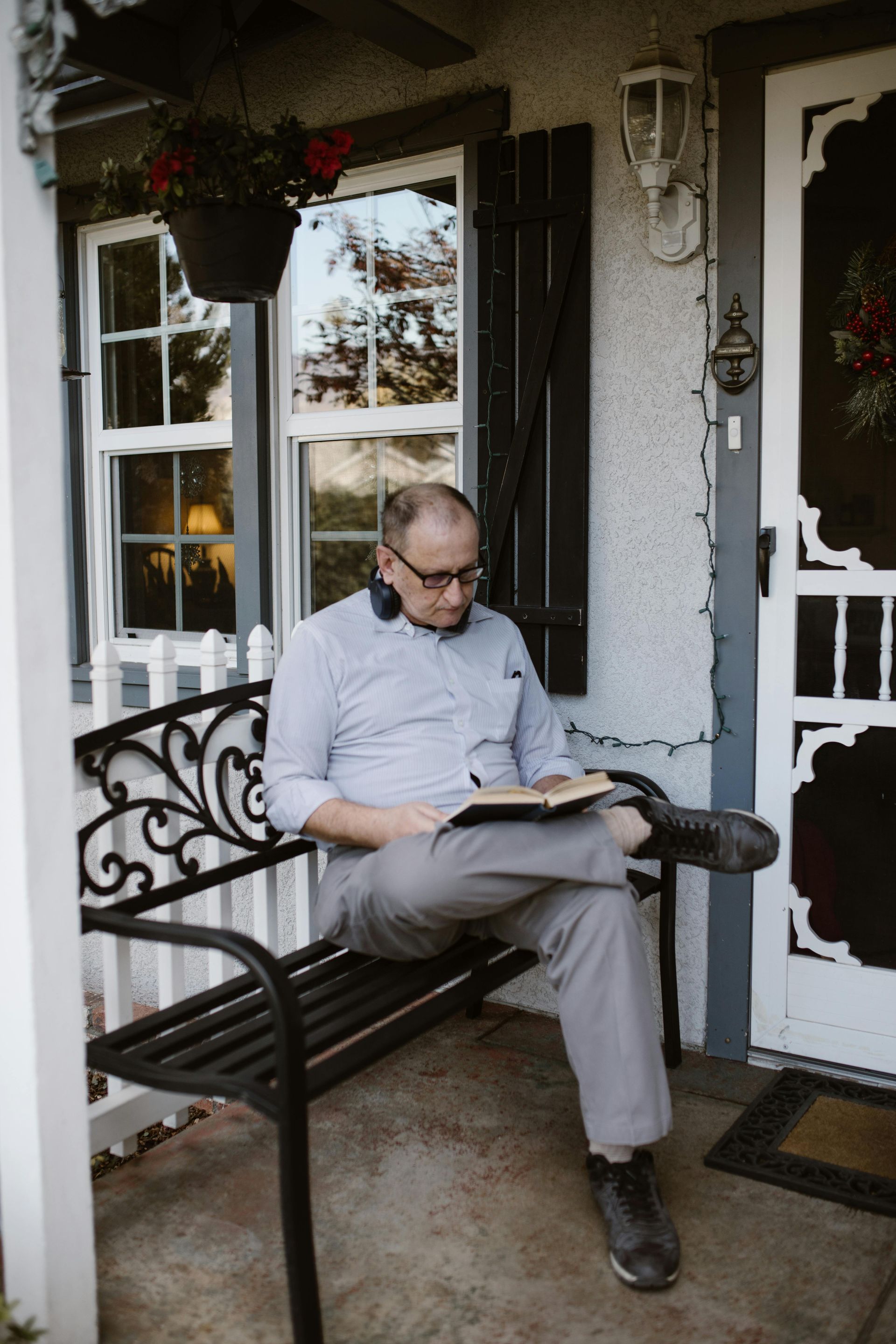 A man is sitting on a bench reading a book.