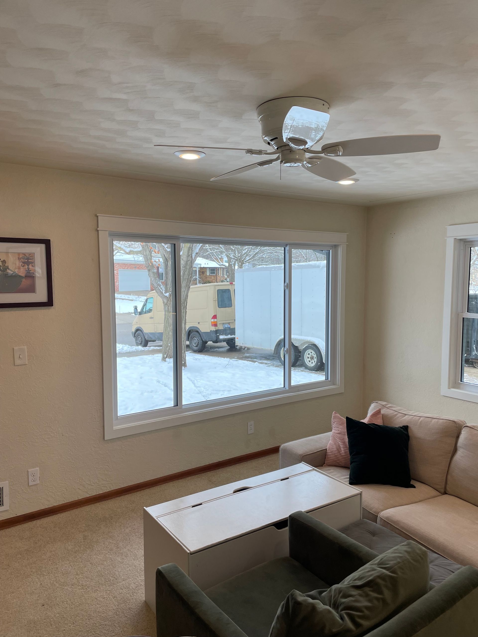 A living room with a couch , coffee table , and ceiling fan.