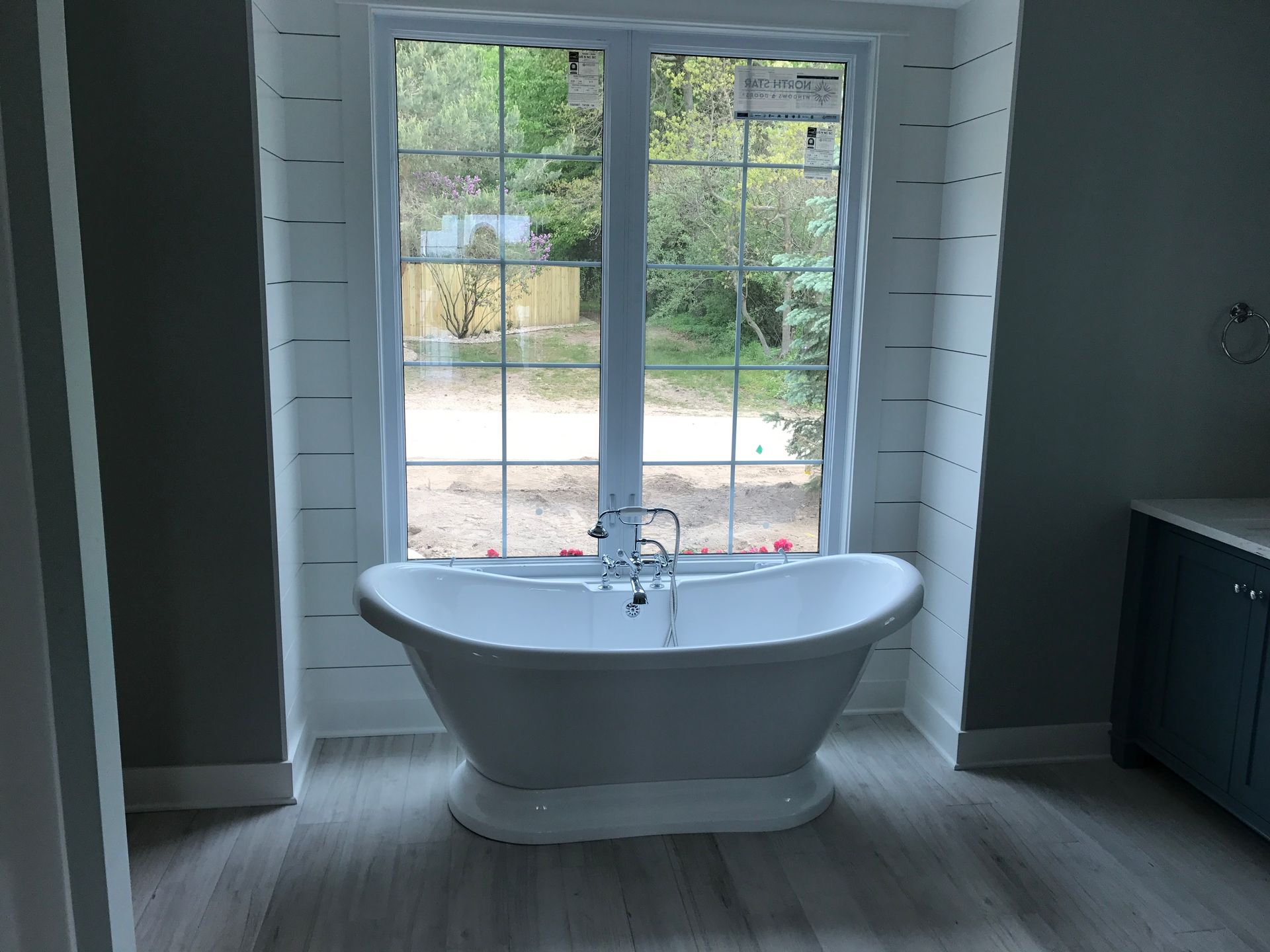 A bathtub in a bathroom next to a window