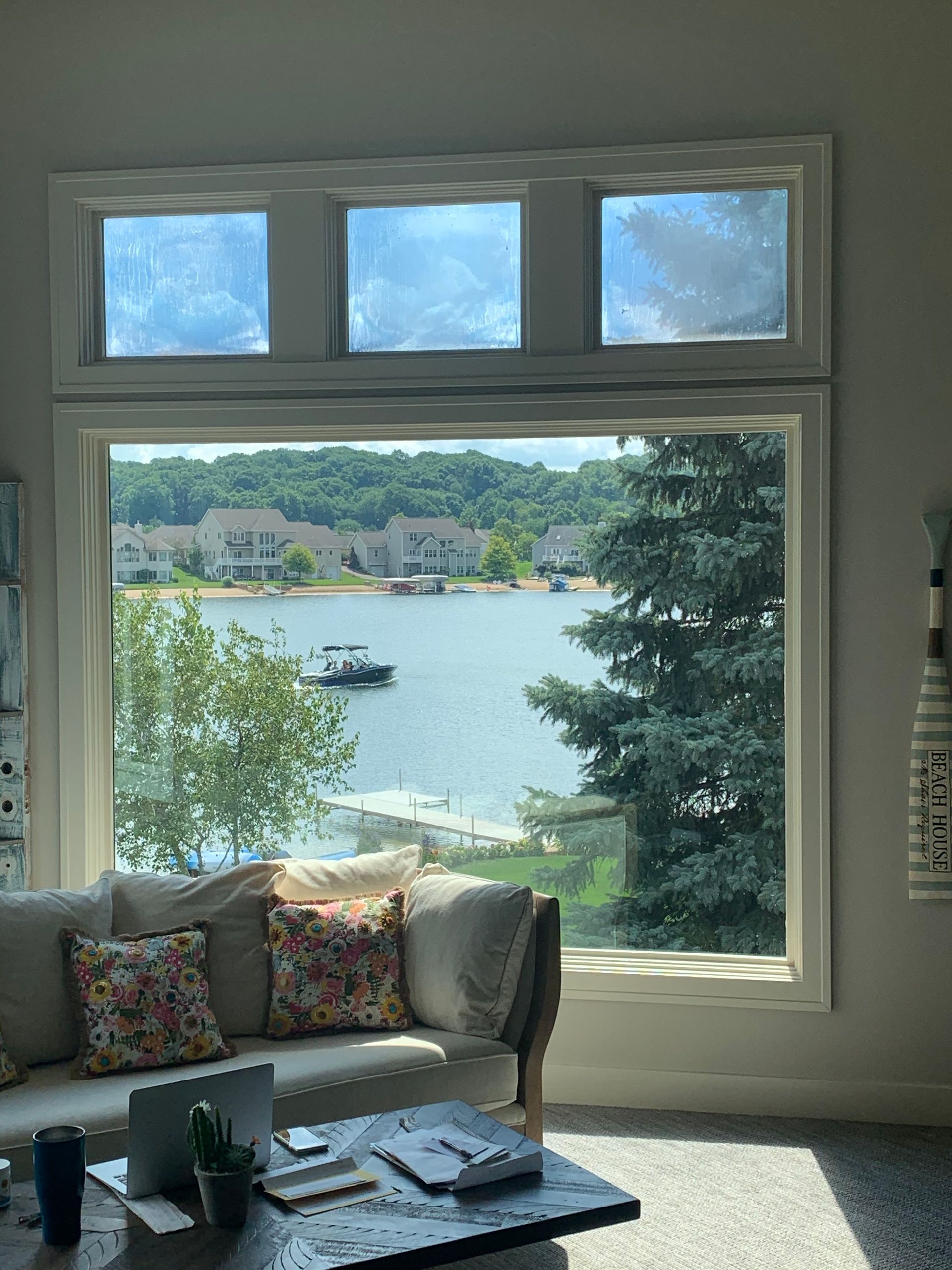A living room with a large window overlooking a lake.